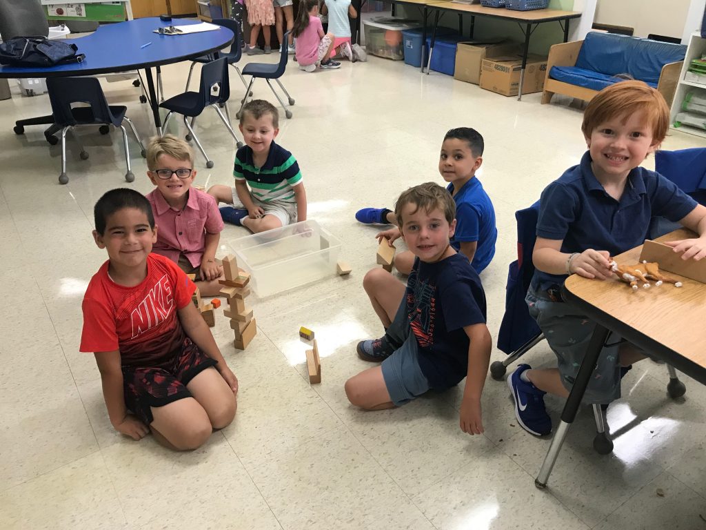 A group of students working together with blocks on the floor