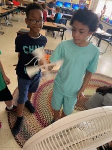 2 students show their wind turbines