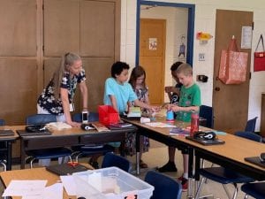 a group of students work intently on building their wind turbine