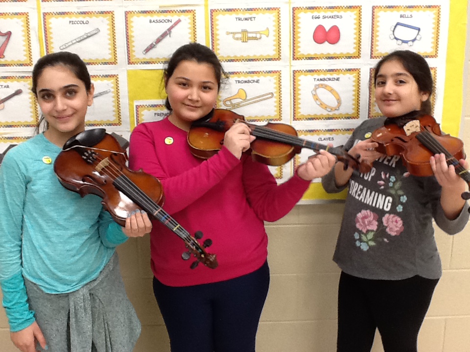 Three viola students wearing their newly awarded Cadet Music Pins.