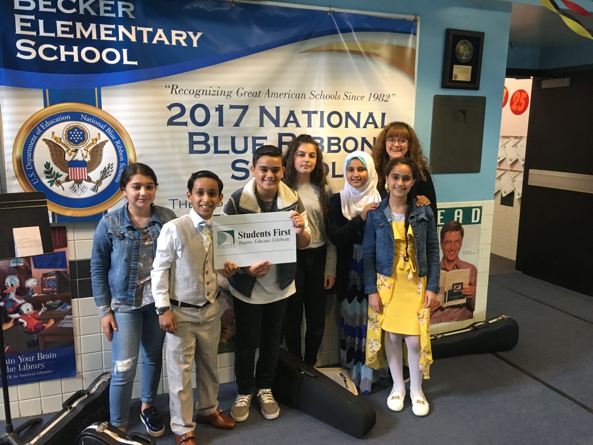 The Becker Violin class and Mrs. Reed pose for Dr. Maleyko with the Dearborn "Students First" sign.
