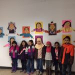Students in front of their artworks