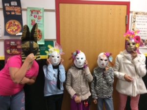 5th graders wearing the paper mache mask they made in Art