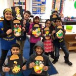 Students posing and showing their finished hamburger collage.