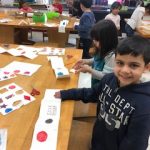 Students are gluing each shape to a page in their book.