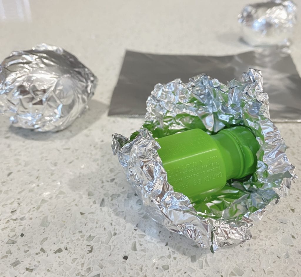 Two aluminum foiled eggs and one unwrapped aluminum foil with bubbles inside.
