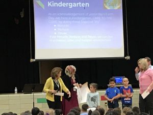 Two teachers and three students presenting to a group.