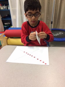 Peeling stickers and placing on a line helps with both fine and visual motor skills.