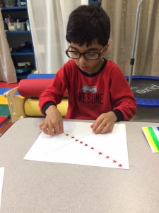 Placing the stickers on dots along the diagonal lines to help refine visual motor skills.
