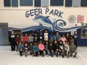 Rangers wearing their hats, Mrs. Timpf, Mrs. Bruce pose in front of the dolphin mural in the cafeteria.