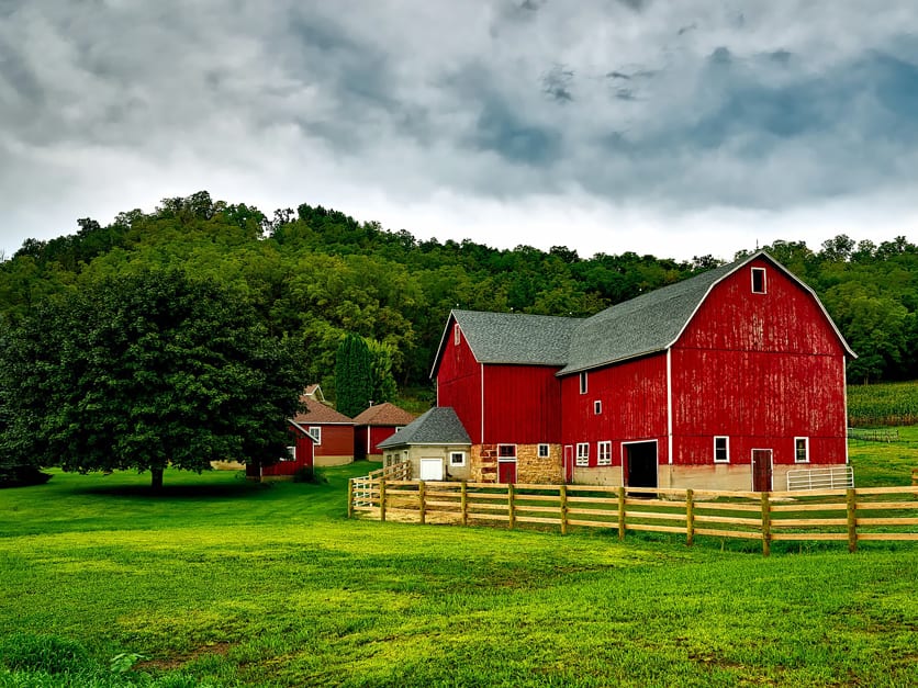Picture of red barn, green trees, and green grass